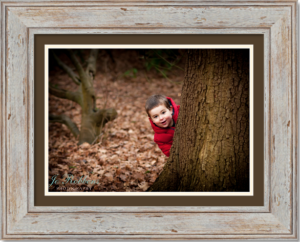 Little boy playing hide and seek in Richmond park