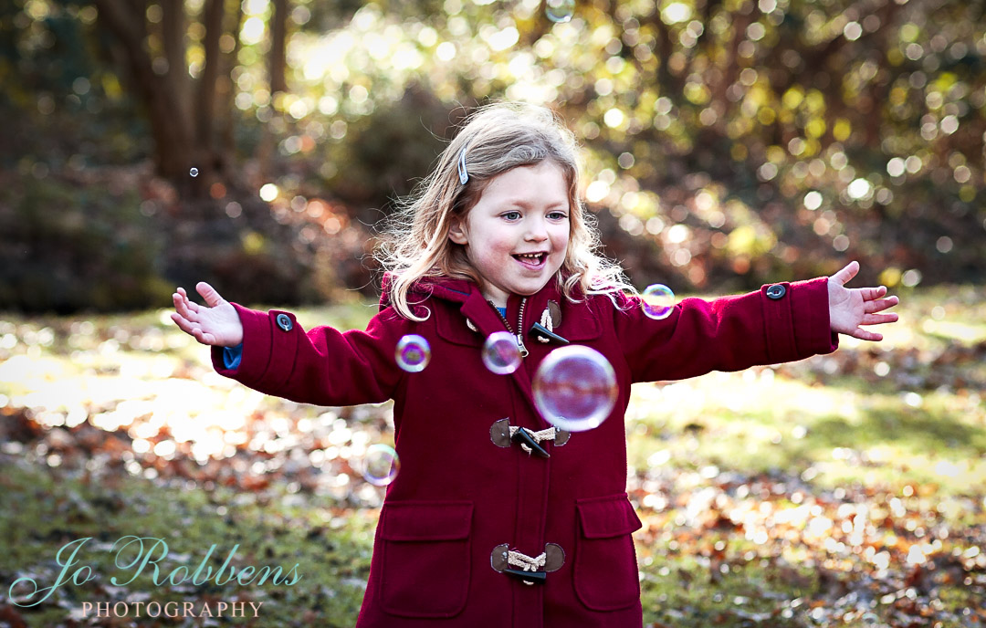 Child having fun with bubbles on a family photoshoot