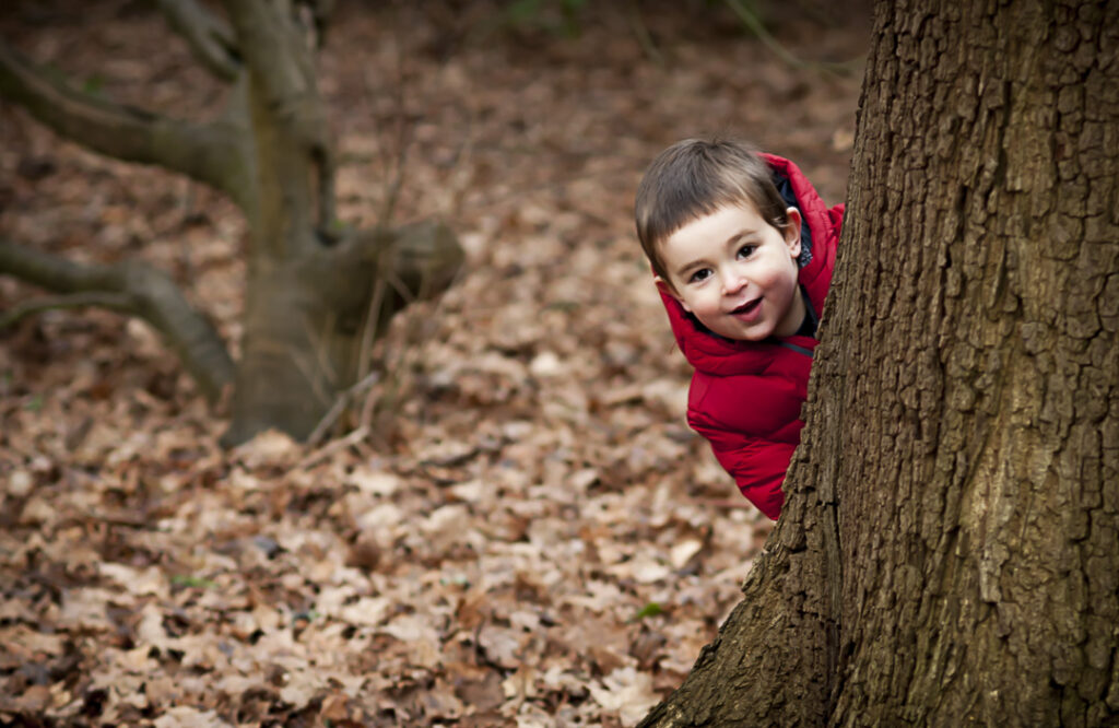 Child and Family Photographer in Surrey_hide and seek on a natural family photoshoot