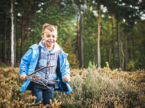 Esher Family Photographer - Young man running through the heather on Esher Commons
