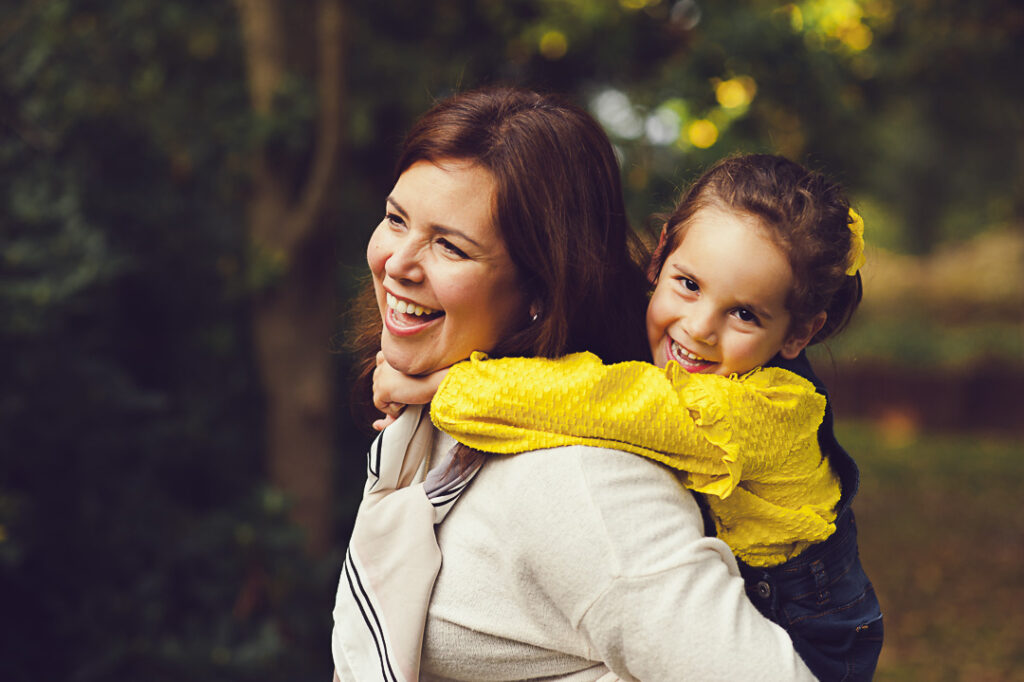 Child and Family Photographer in Surrey_enjoying a piggie back ride during a family photoshoot