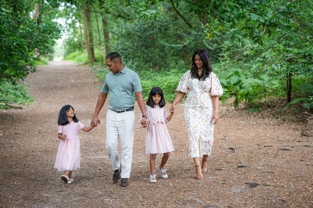 Family laughing together during an outdoor photoshoot at golden hour
