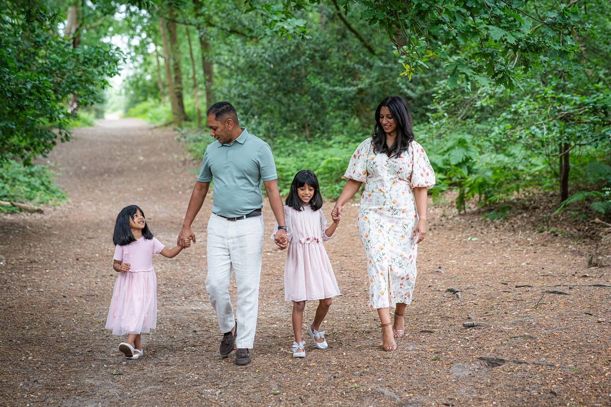 Family laughing together during an outdoor photoshoot at golden hour