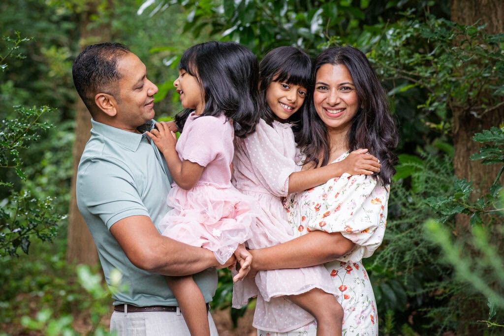Candid outdoor family portrait with trees and natural background