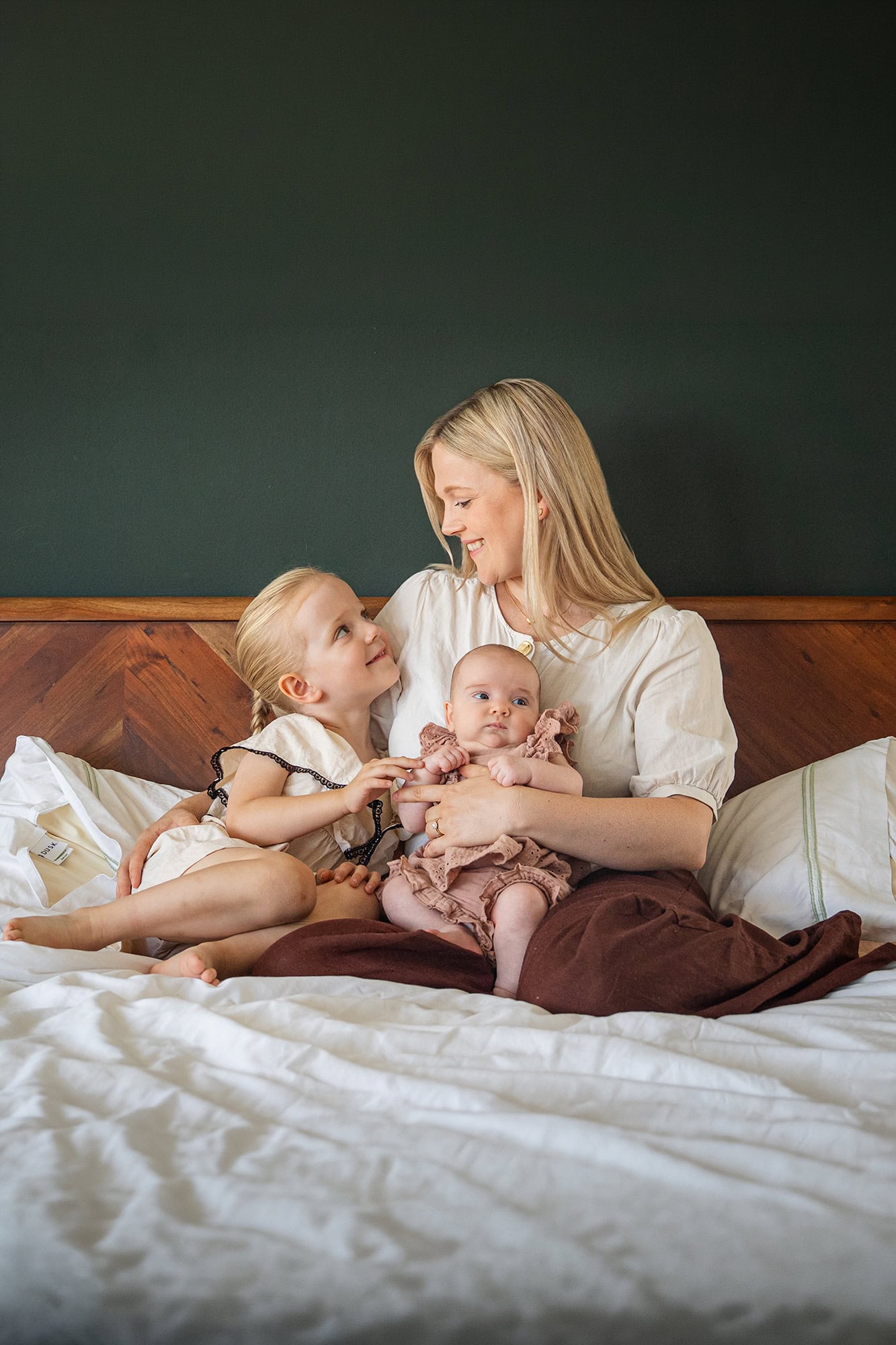 A mum with her new two daughters one is a new born and the other a toddler